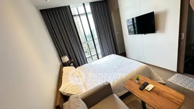 Modern bedroom with large window and city view, featuring a cozy bed and wall-mounted TV.