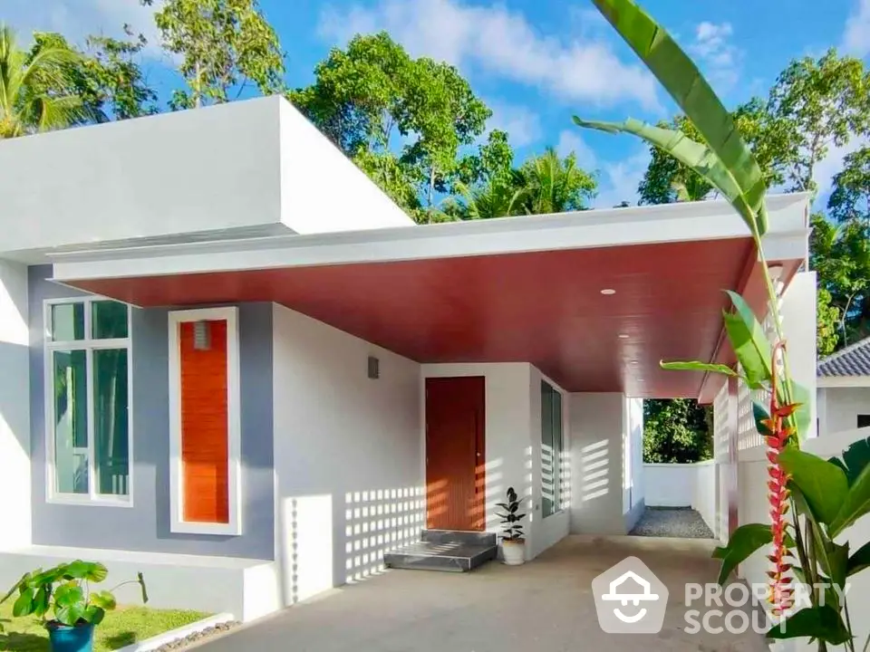 Modern minimalist house exterior with sleek design and lush greenery, featuring a stylish carport and vibrant plants.