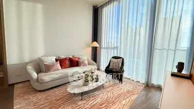 Elegant living room with modern decor, large windows, and cozy seating area.