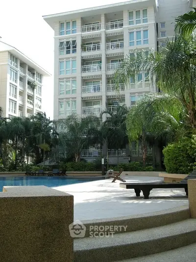 Luxurious residential building with pool and lush greenery, perfect for modern living.
