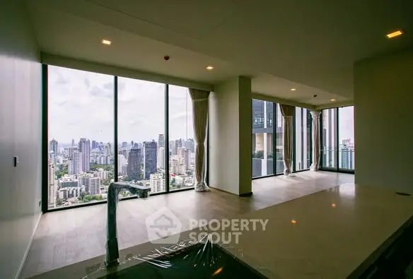 Luxurious high-rise apartment with panoramic city views and expansive windows.