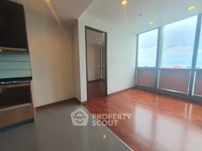 Spacious corner unit with gleaming hardwood floors and ample natural light, featuring large windows and a modern, open layout.