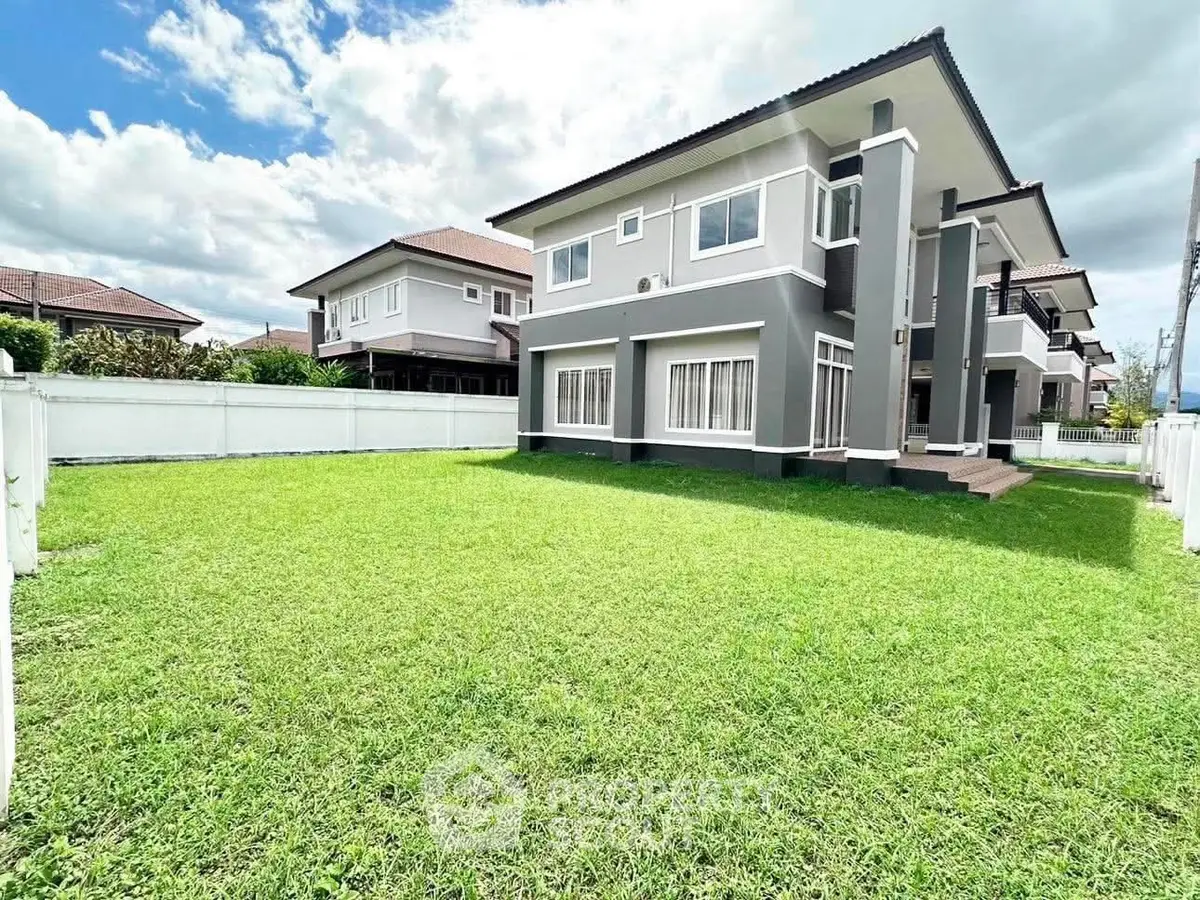 Spacious modern home with lush green lawn and elegant exterior design.