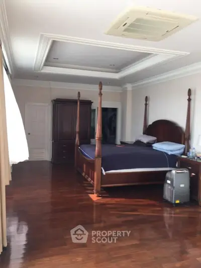 Spacious bedroom with elegant wooden furniture and polished hardwood floors