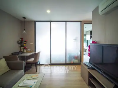 Modern living room with frosted glass partition and cozy seating area.
