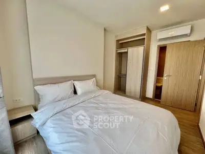 Cozy bedroom with modern furnishings and ample closet space in a stylish apartment.