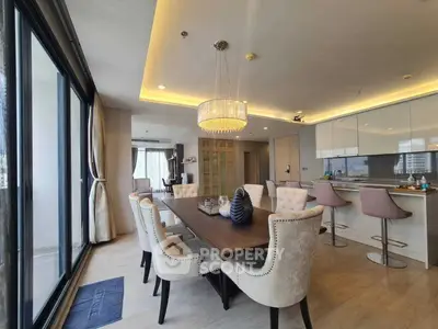 Luxurious open-plan dining and living area with elegant decor and modern kitchen.