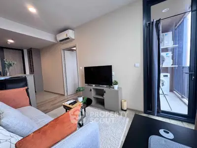 Modern living room with balcony and washing machine, featuring sleek furniture and open layout.