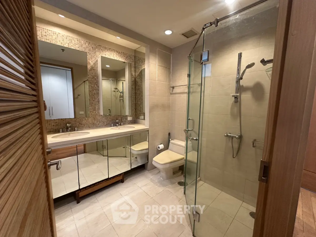 Luxurious modern bathroom with glass shower and dual sinks