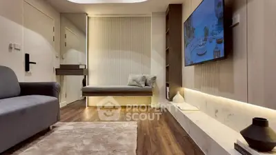 Modern living room with sleek design and wall-mounted TV, featuring cozy seating and elegant decor.