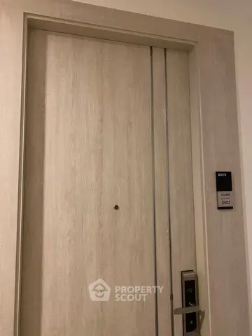 Modern apartment entrance with sleek wooden door and electronic lock