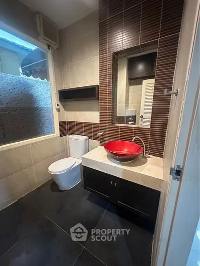 Modern bathroom with stylish red basin and sleek tile design