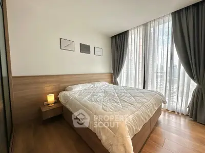 Modern bedroom with large windows and elegant decor in a stylish apartment.