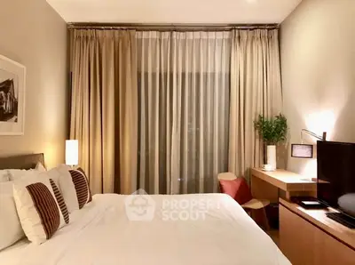 Cozy bedroom with elegant decor and natural lighting, featuring a comfortable bed and stylish desk area.