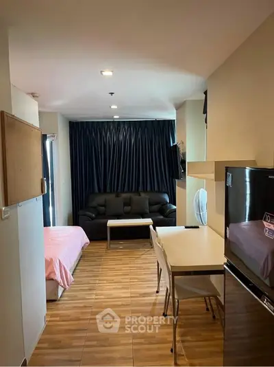 Modern studio apartment with open layout, featuring cozy living area and compact kitchen.