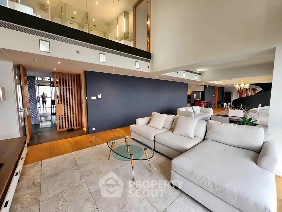 Luxurious modern living room with high ceilings and elegant decor in a spacious open-plan layout.