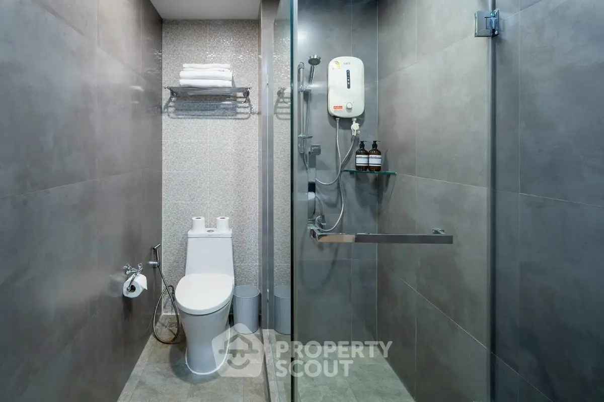 Modern bathroom with sleek shower and toilet in contemporary design.