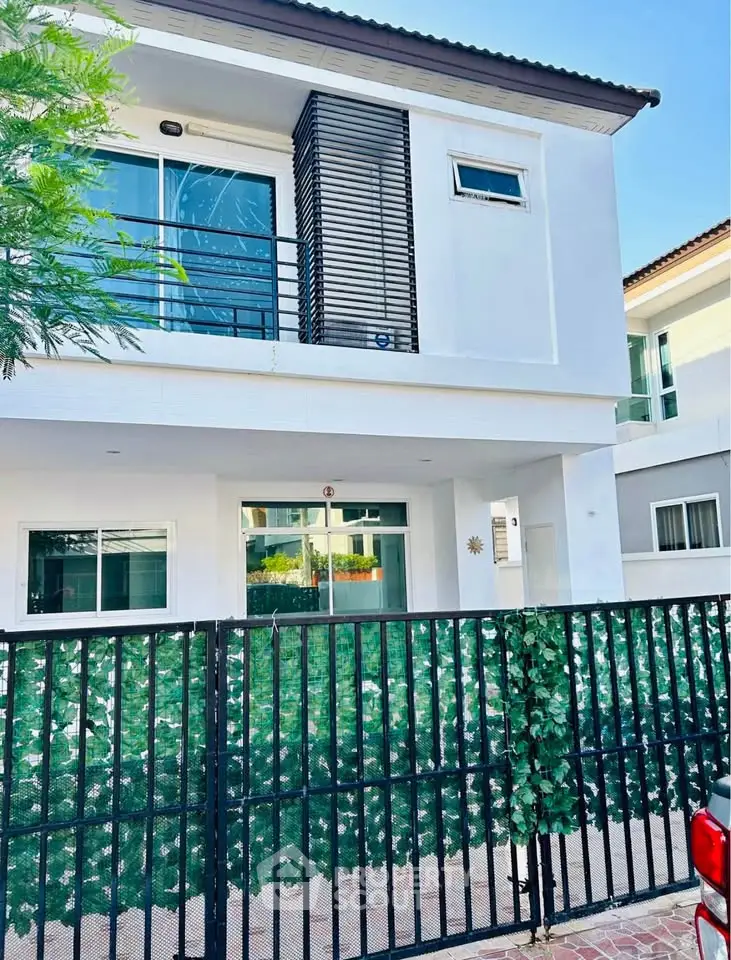 Modern two-story house with gated entrance and contemporary design in a serene neighborhood.