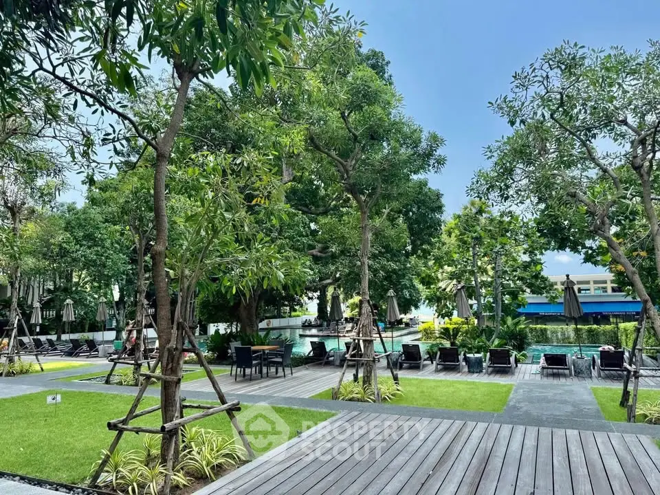 Luxurious outdoor pool area with lush greenery and modern seating, perfect for relaxation and leisure.