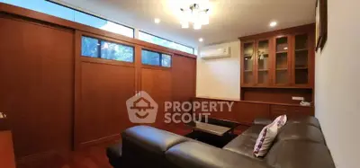 Spacious living room with elegant wooden cabinetry and modern leather sofa