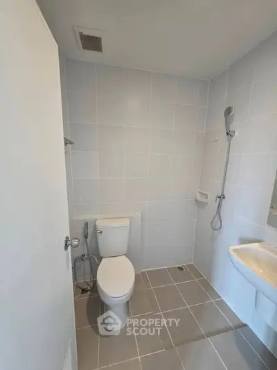 Modern bathroom with sleek tiles and shower in a minimalist design.