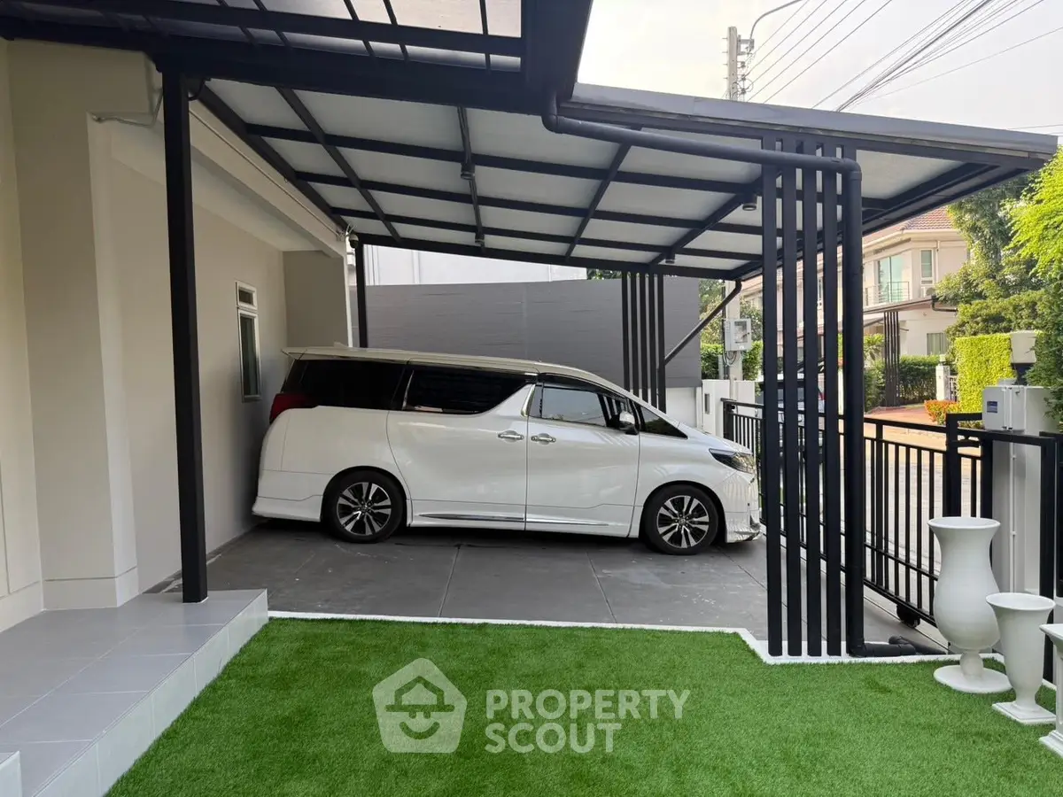 Modern covered parking area with sleek white vehicle and lush green artificial turf