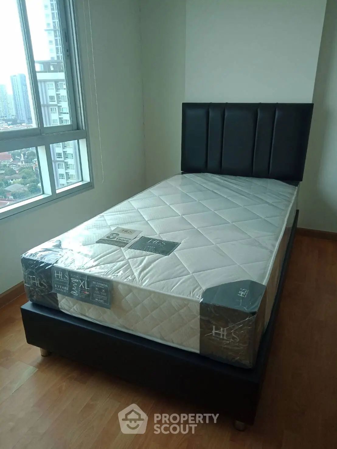 Modern bedroom with single bed and city view, perfect for urban living.