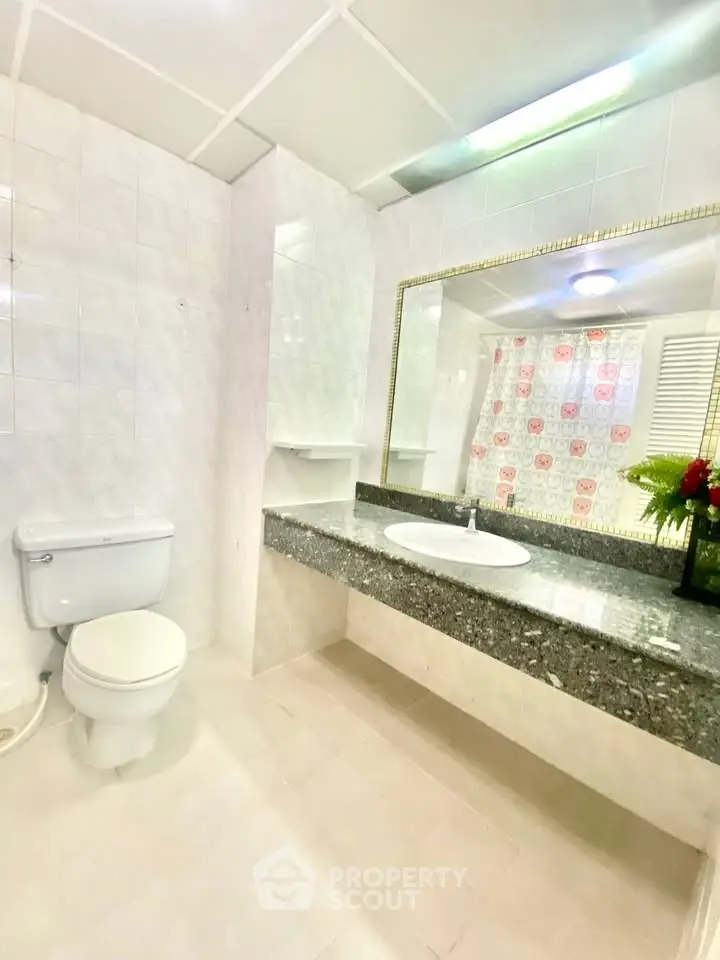 Spacious bathroom with elegant granite countertop and large mirror, perfect for modern living.