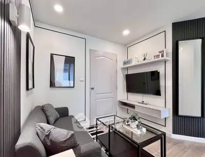 Modern living room with sleek design, featuring a gray sofa, wall-mounted TV, and stylish decor.