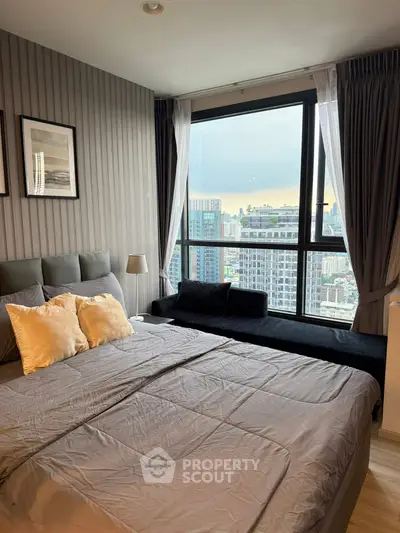 Modern bedroom with city view, featuring cozy bed and stylish decor.