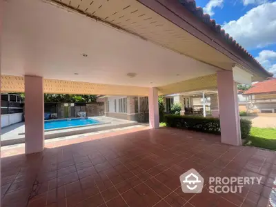 Spacious covered patio with pool view in luxurious villa