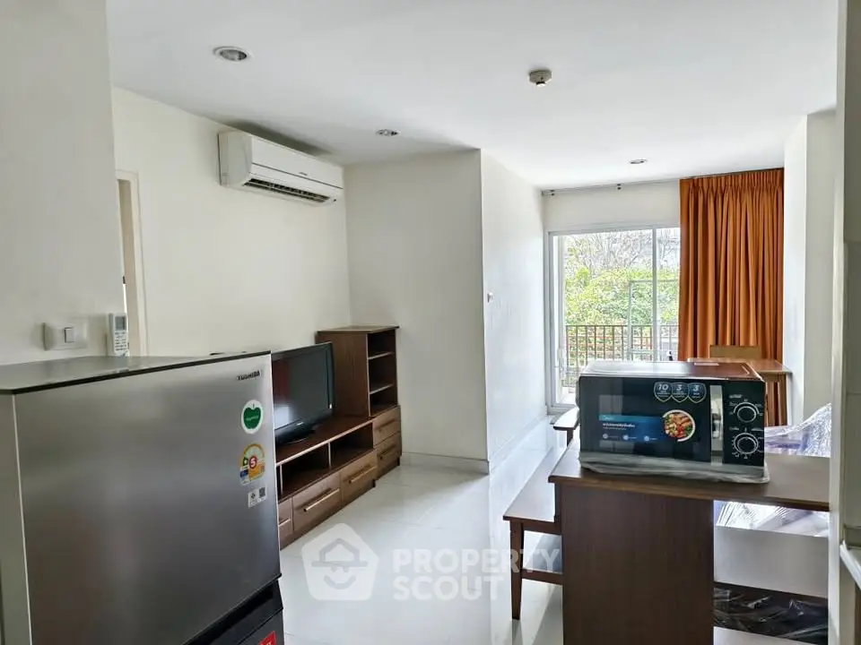 Modern living room with balcony, featuring air conditioning and sleek furniture, perfect for comfortable living.