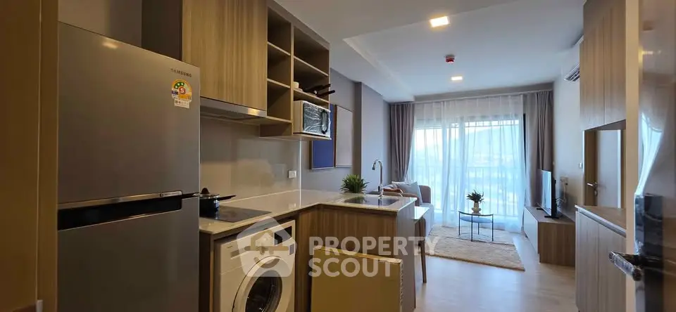 Modern open-plan kitchen and living room with stylish decor and natural light.