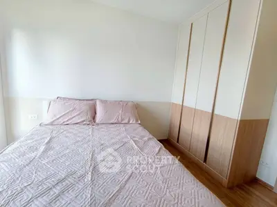 Cozy bedroom with stylish wardrobe and soft pink bedding in modern apartment.