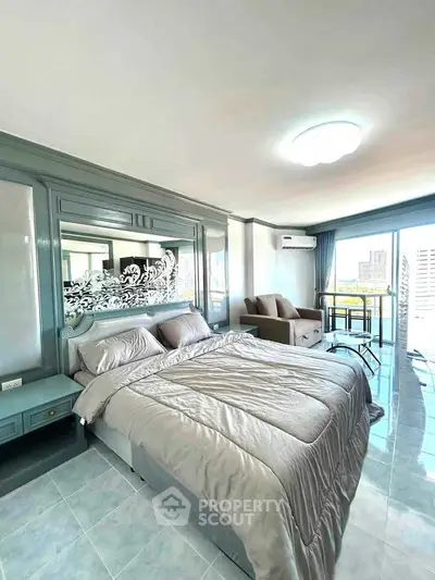 Spacious bedroom with modern decor and balcony view in a high-rise apartment.