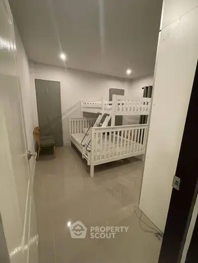 Spacious bedroom with modern bunk bed and sleek tile flooring.