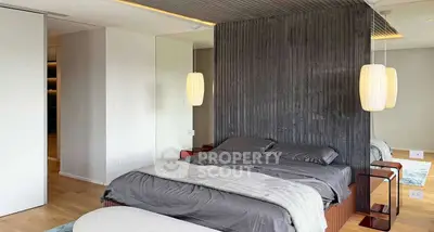Modern bedroom with stylish decor and elegant lighting, featuring a cozy bed and sleek design elements.