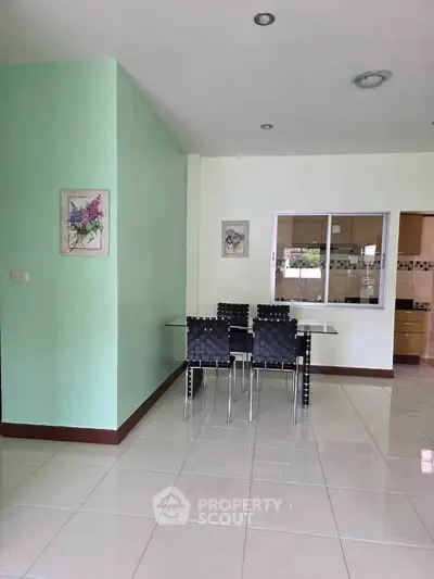 Modern dining area with sleek glass table and stylish chairs in a spacious, bright interior.