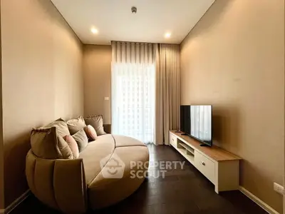 Cozy living room with modern sofa and flat-screen TV, perfect for relaxation.