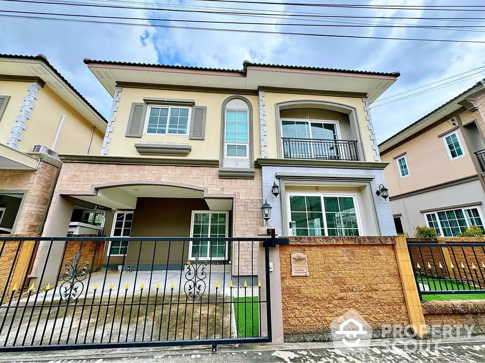 Stunning two-story house with modern facade and gated entrance in a serene neighborhood.