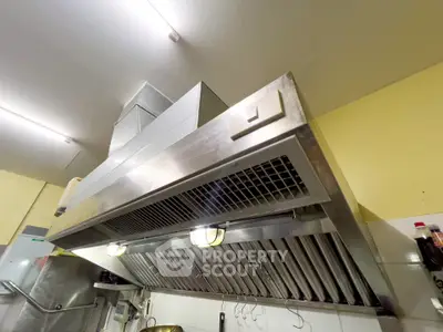 Modern kitchen with stainless steel range hood and bright lighting