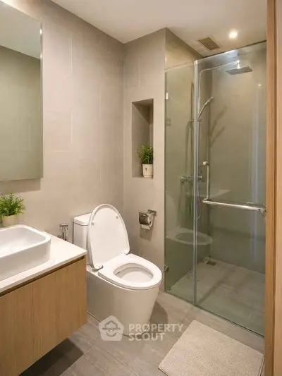 Modern bathroom with glass shower, sleek vanity, and neutral tones.