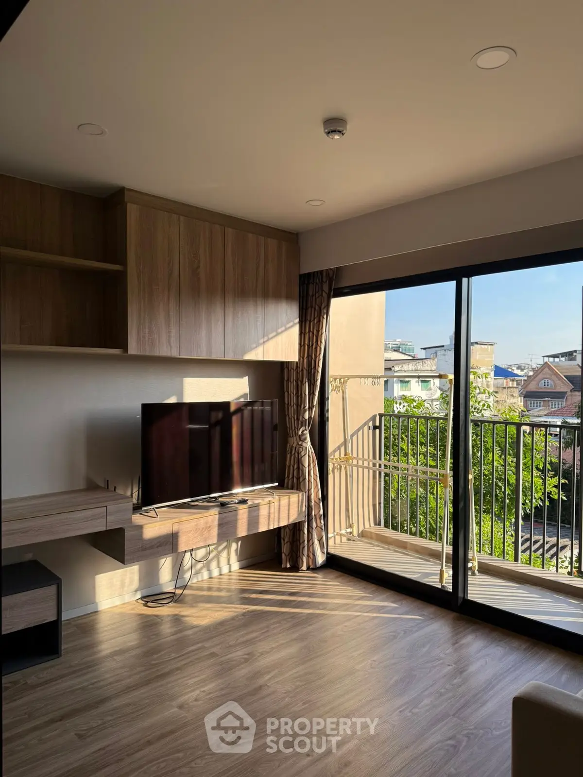 Modern living room with balcony view and sleek wooden furniture