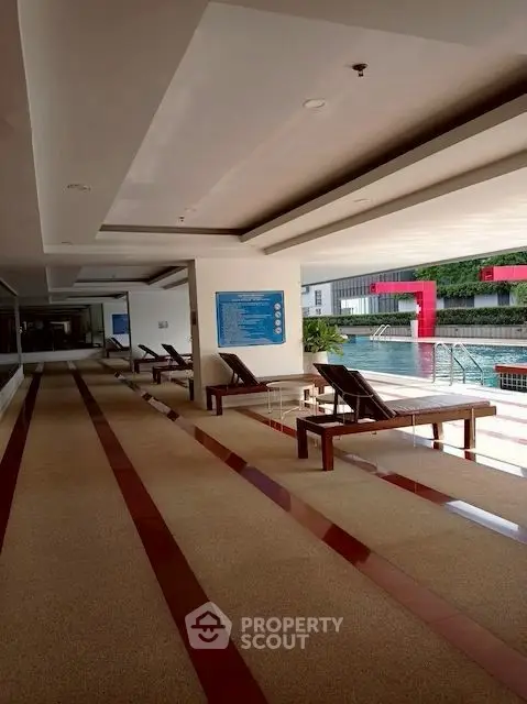Luxurious indoor pool area with lounge chairs and modern design, perfect for relaxation and leisure.