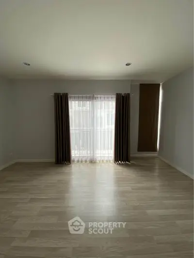 Spacious empty room with large window and elegant curtains, perfect for customization.