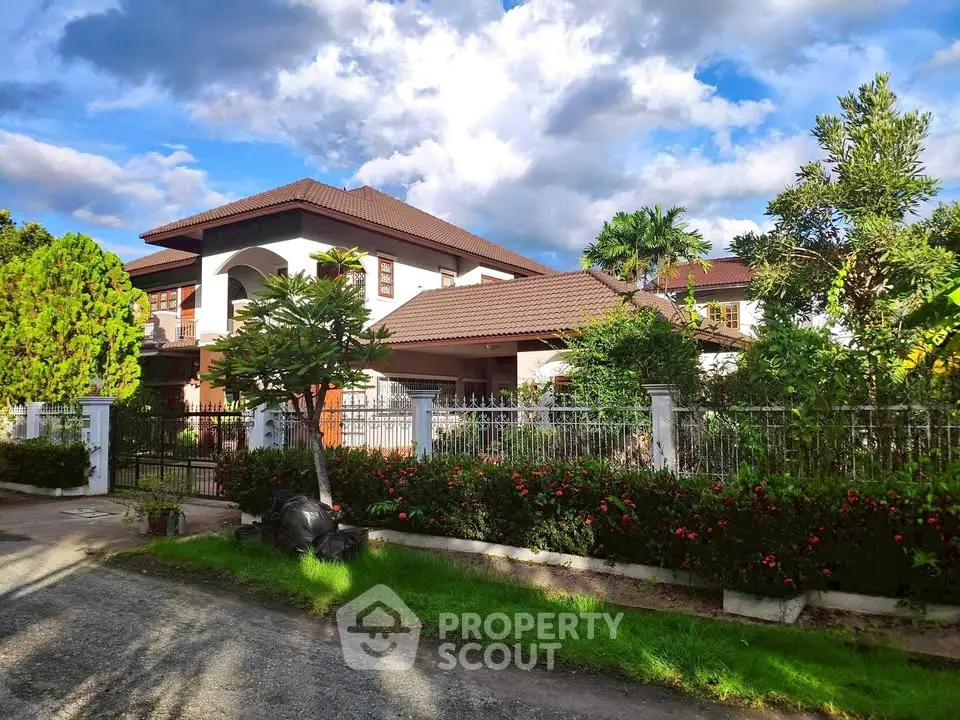 Stunning two-story house with lush garden and elegant architecture under a vibrant sky.
