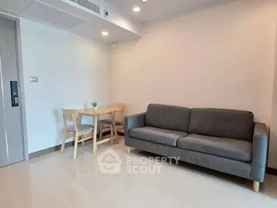 Modern living room with sleek sofa and dining table in a cozy apartment.