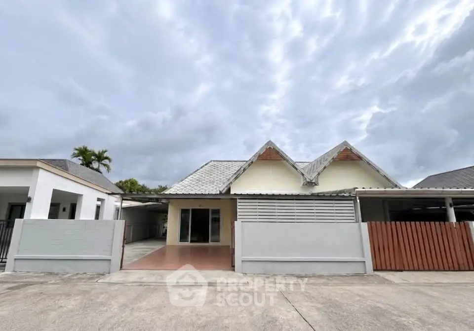 Charming single-story home with unique roof design and spacious driveway in a serene neighborhood.