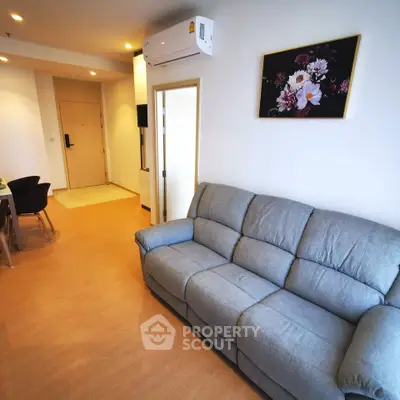 Modern living room with cozy gray sofa and stylish wall art in a bright apartment.