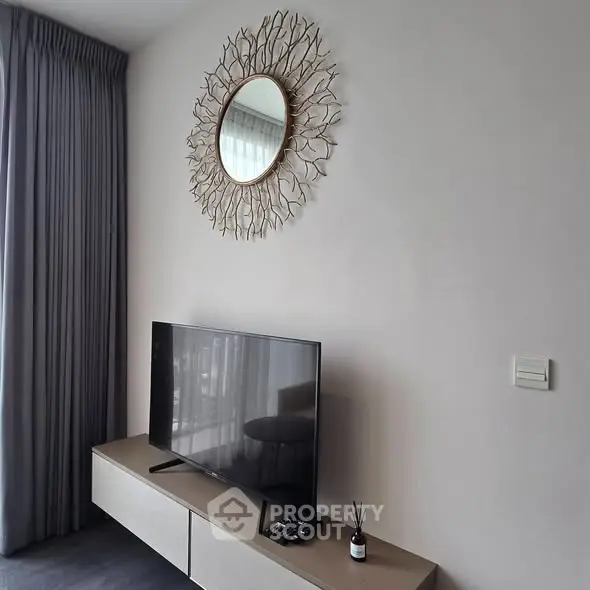 Modern living room with stylish decor and flat-screen TV on sleek console.